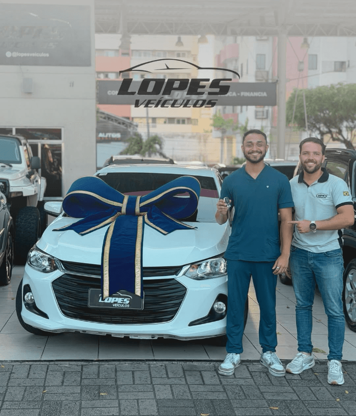 Cliente recebendo as chaves de um Chevrolet Onix branco na Lopes Veículos