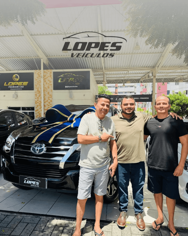 Cliente ao lado da equipe na entrega de uma Toyota SW4 preta na Lopes Veículos